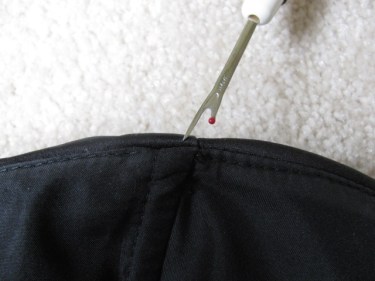 Photo of a seam ripper taking out the stitches in Michelle's black bridesmaid top preparing for a gusset. 1070. How to put gussets in a dress or top