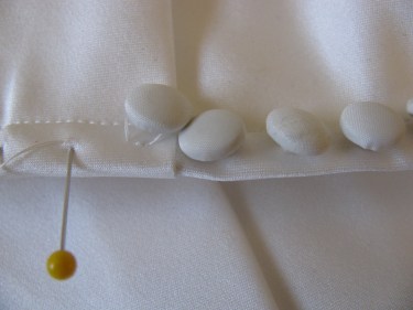 another photo of a satin covered button after the blood was removed with saliva.