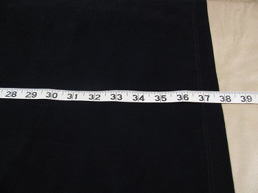 Measuring the black dress for the hem on the ironing board