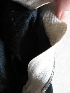 8358, flipping up the elastic on a pair of shorts to expose the elastic