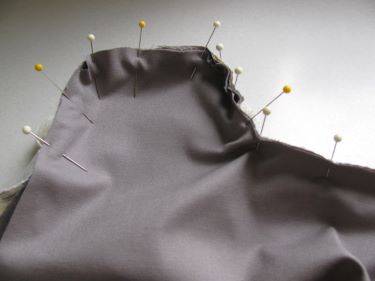 pinning the upper fabric to the cushion strip with piping